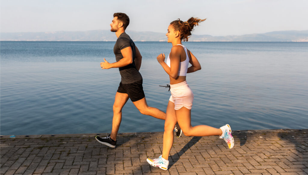 lifestyle photo of a couple running near a waterfront